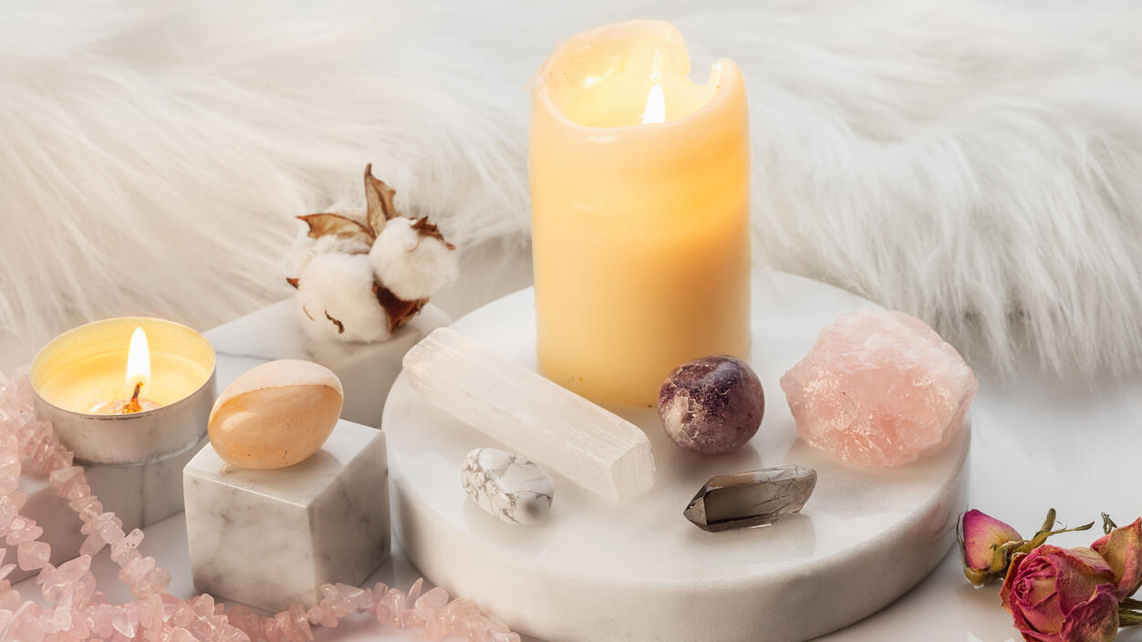 a beautiful and peaceful photo with candles, crystals, and soft fur blanket